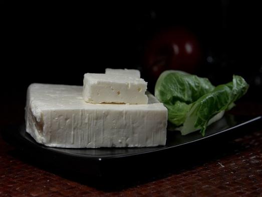 A homemade cheese mold on a plate with lettuce and tomato